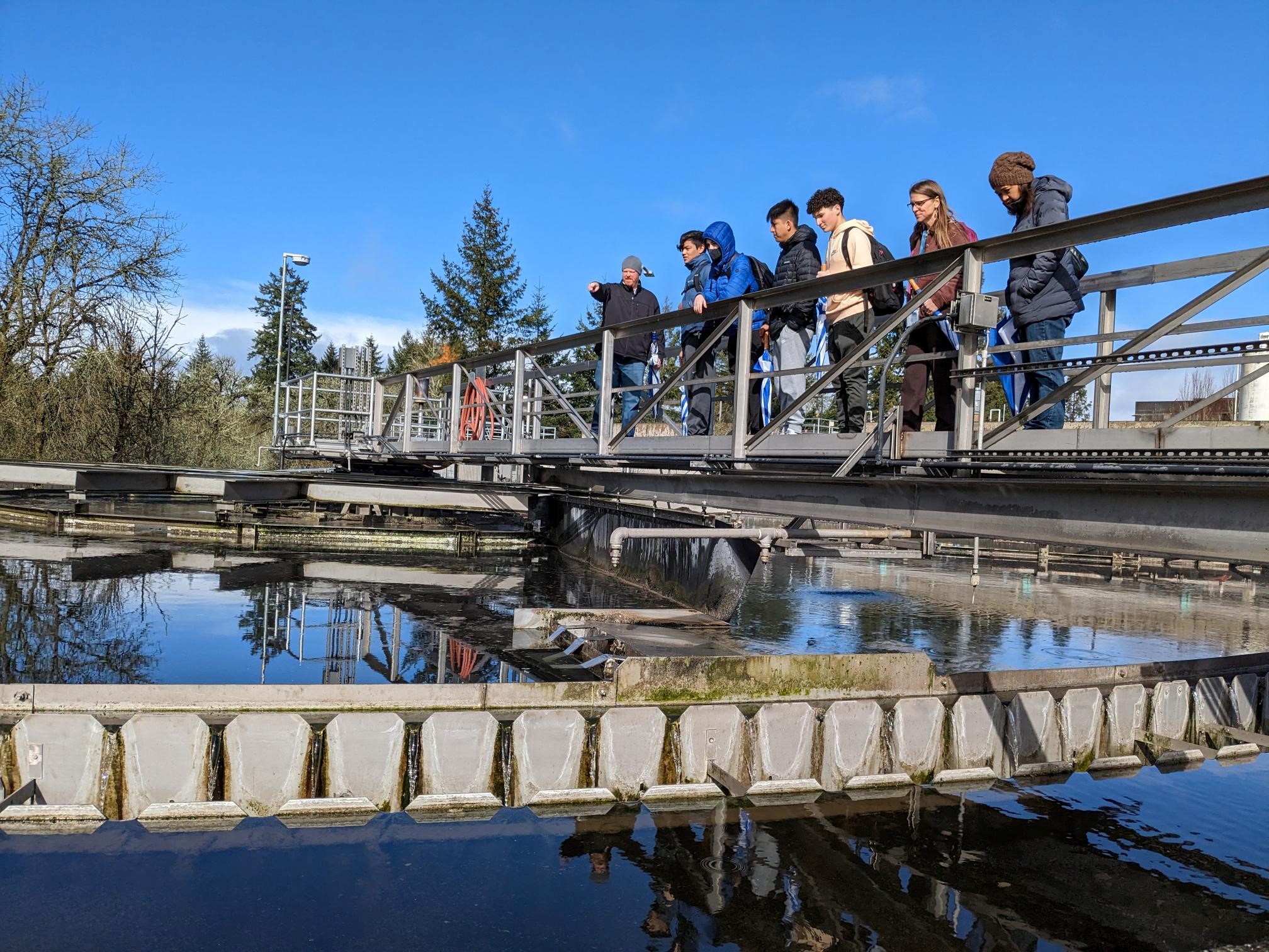A group of people on the catwalk above a primary clarifier at A CWS Water Resource Recovery Facility.