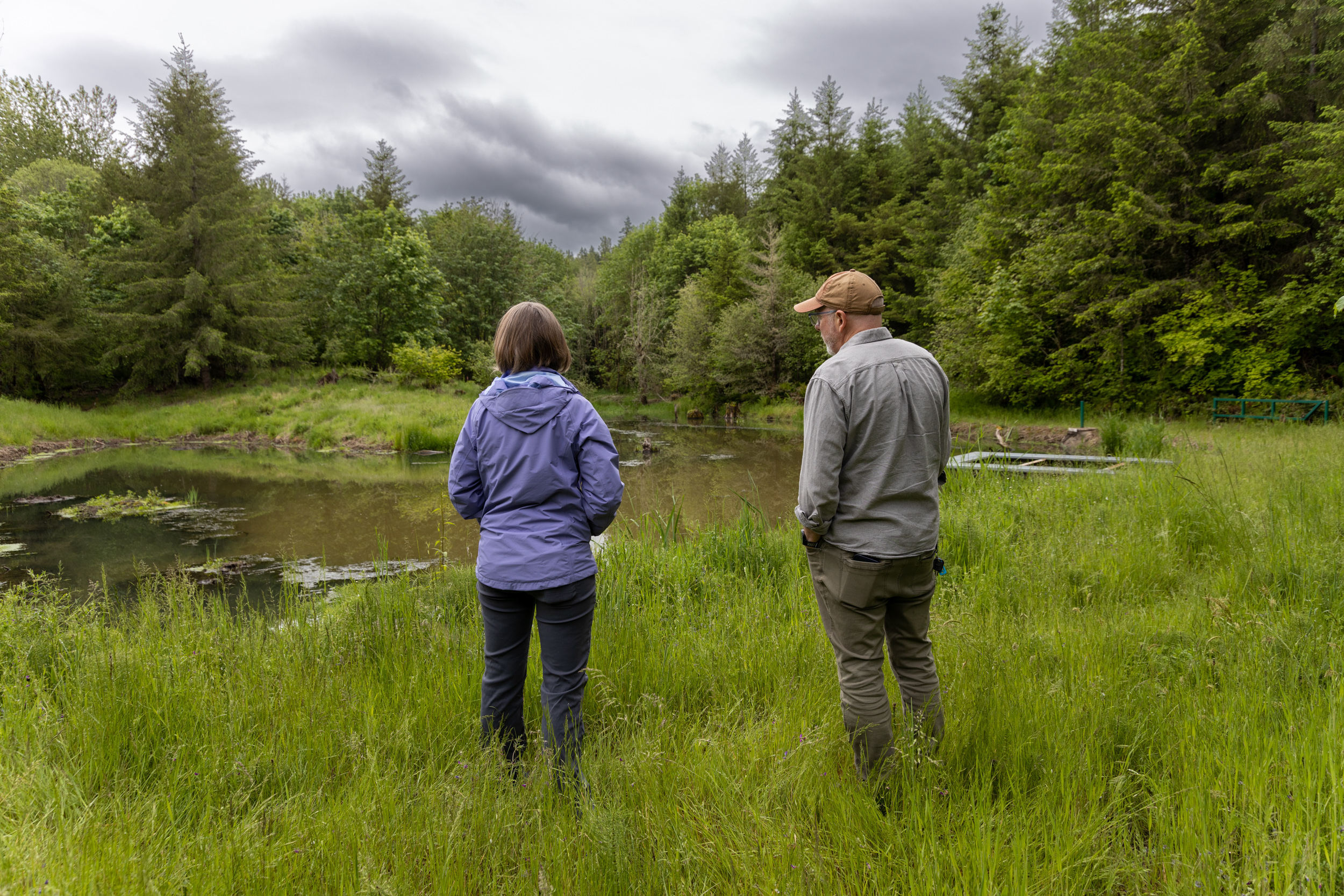 An image to two people standing in front of the Tualatin River.